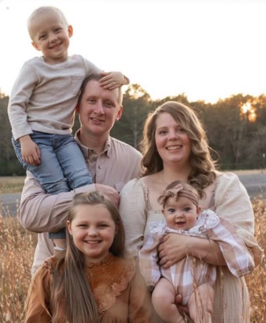 The Laws family standing in a field at sunset